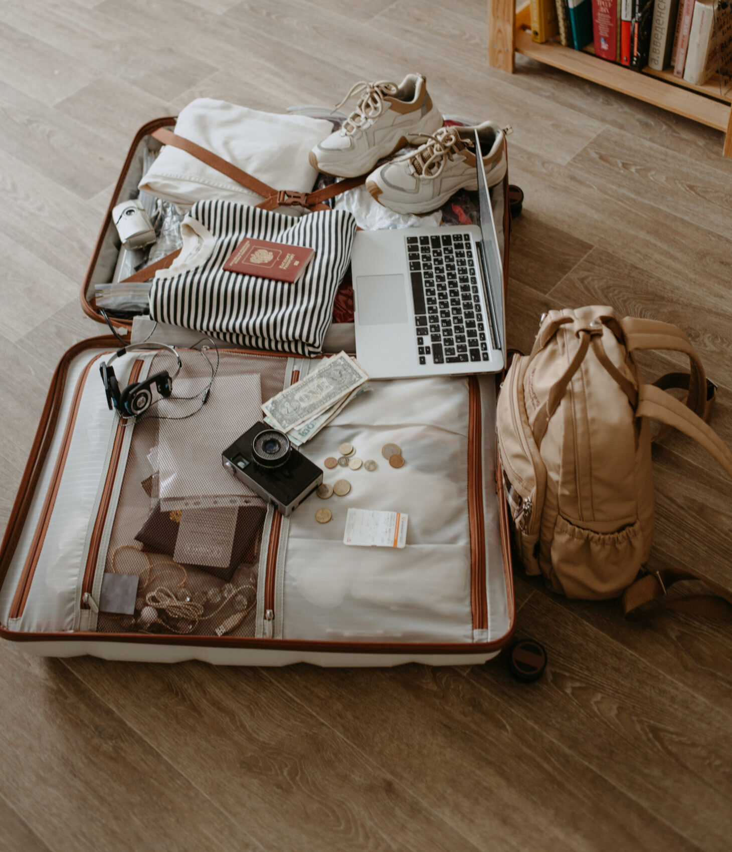 equipaje abierto con snickers sueter portatil auriculares y pasaporte camara vintage y mochila equipaje abierto con snickers sueter portatil auriculares y pasaporte camara vintage y mochila
