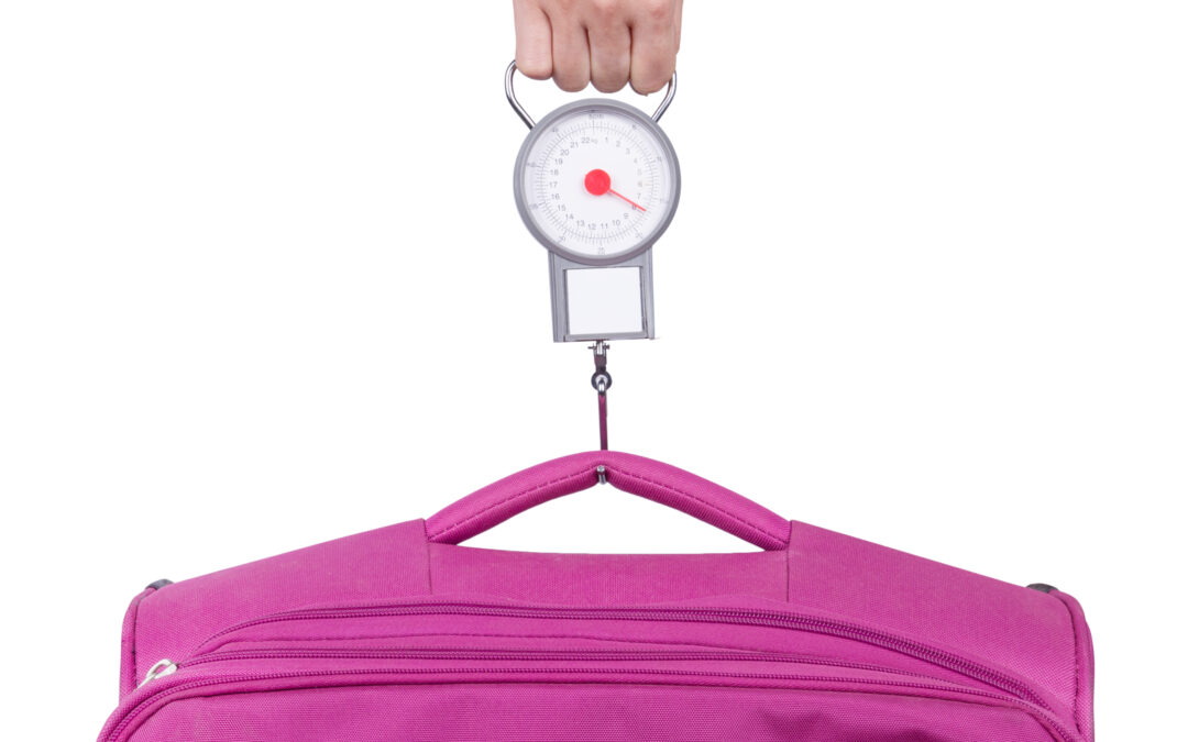 Passenger checking luggage weight with scale before flight isola